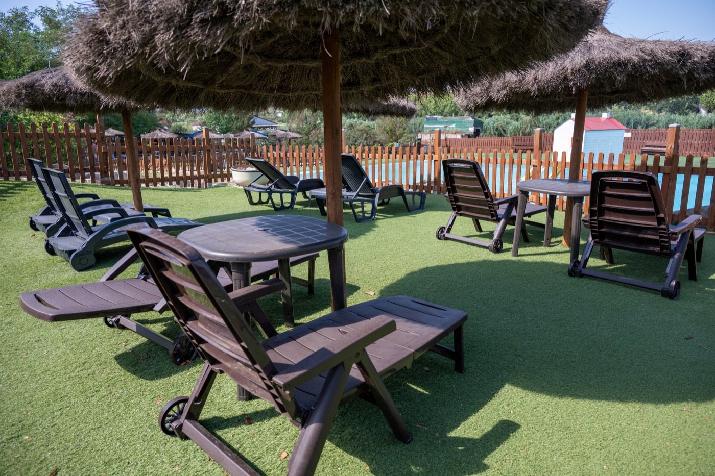 Zona de descanso con sombra junto a las piscinas